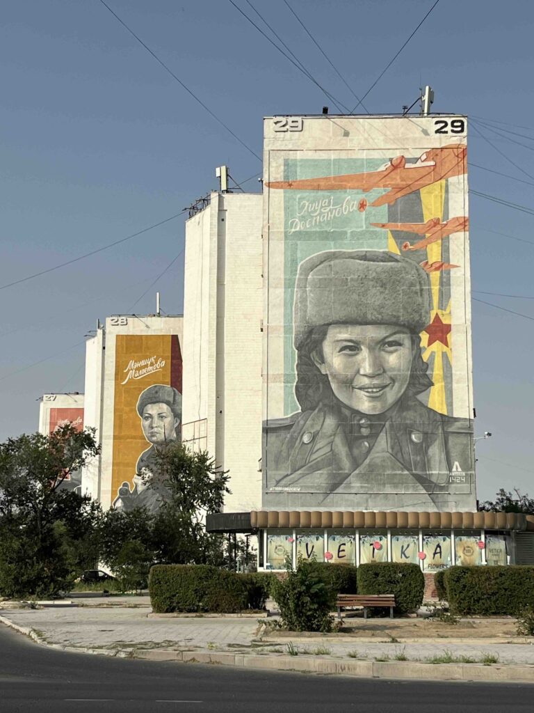 Large scale murals on residential buildings, featuring a female in a soviet uniform